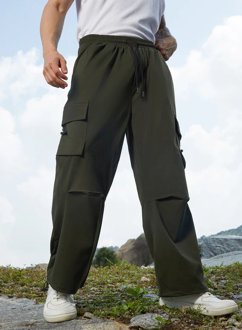 Campus Sutra Men's Army Green Solid Cargo Parachute Trousers For Casual Wear | Relaxed Fit | Low-Rise | Button Closure | Cargo Pants Crafted With Comfort Fit For Everyday Wear